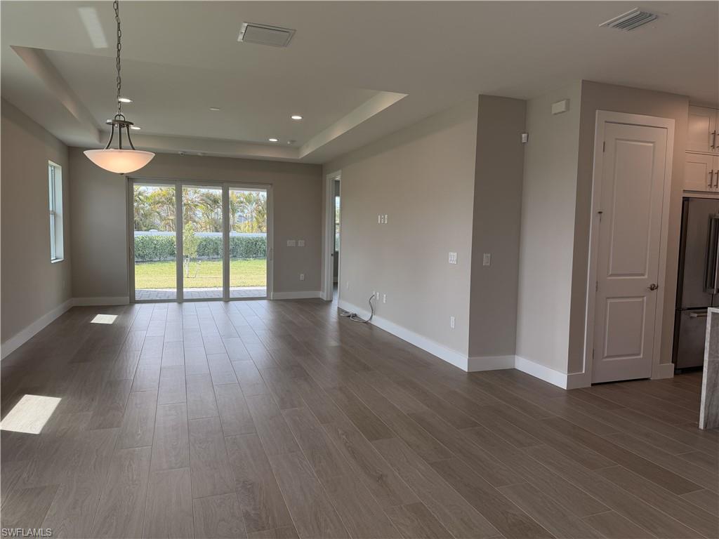8909 Oceana Way Naples, FL 34114 - Photo 11 of 41 a view of an empty room with wooden floor and a window