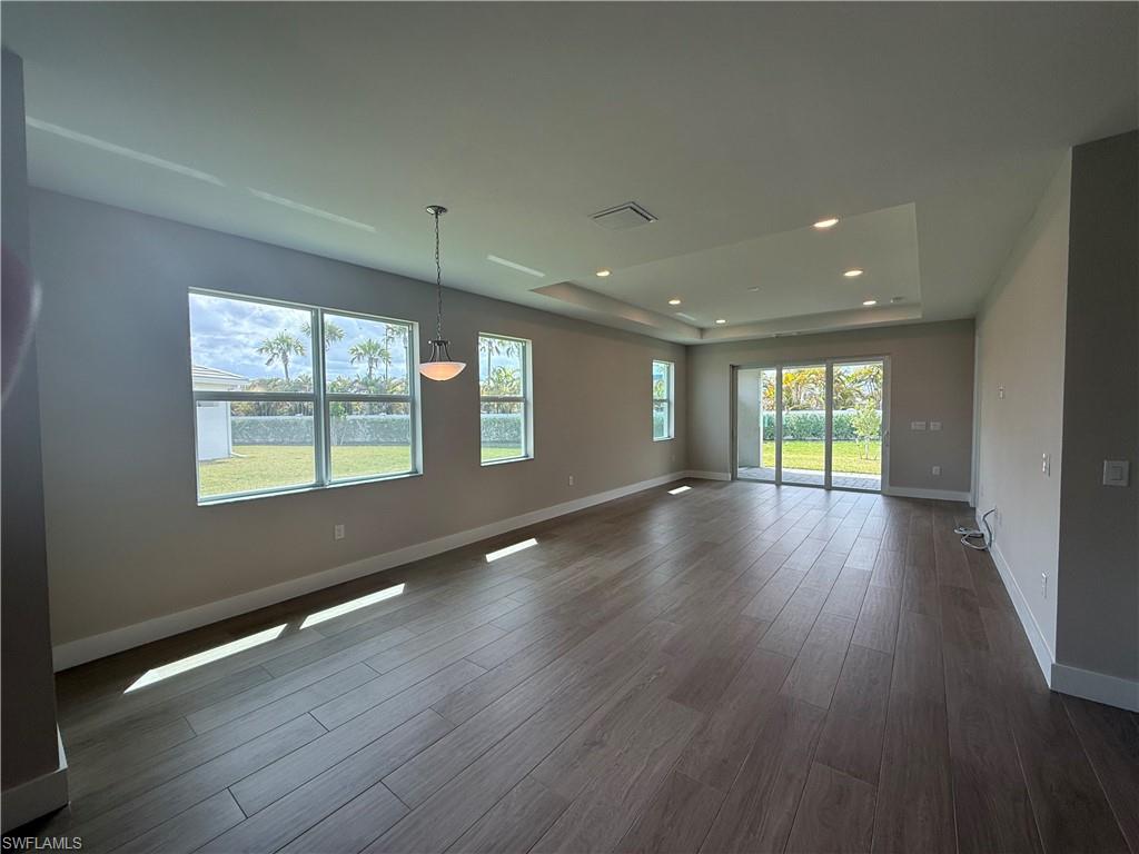 8909 Oceana Way Naples, FL 34114 - Photo 12 of 41 a view of an empty room with wooden floor and a window