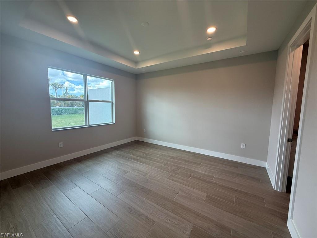 8909 Oceana Way Naples, FL 34114 - Photo 15 of 41 an empty room with wooden floor and windows