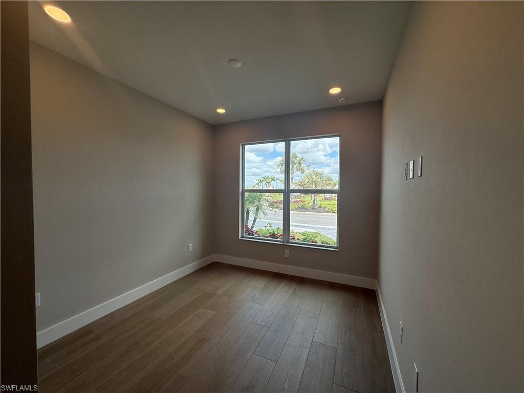 8909 Oceana Way Naples, FL 34114 - Photo 18 of 41 an empty room with wooden floor and windows