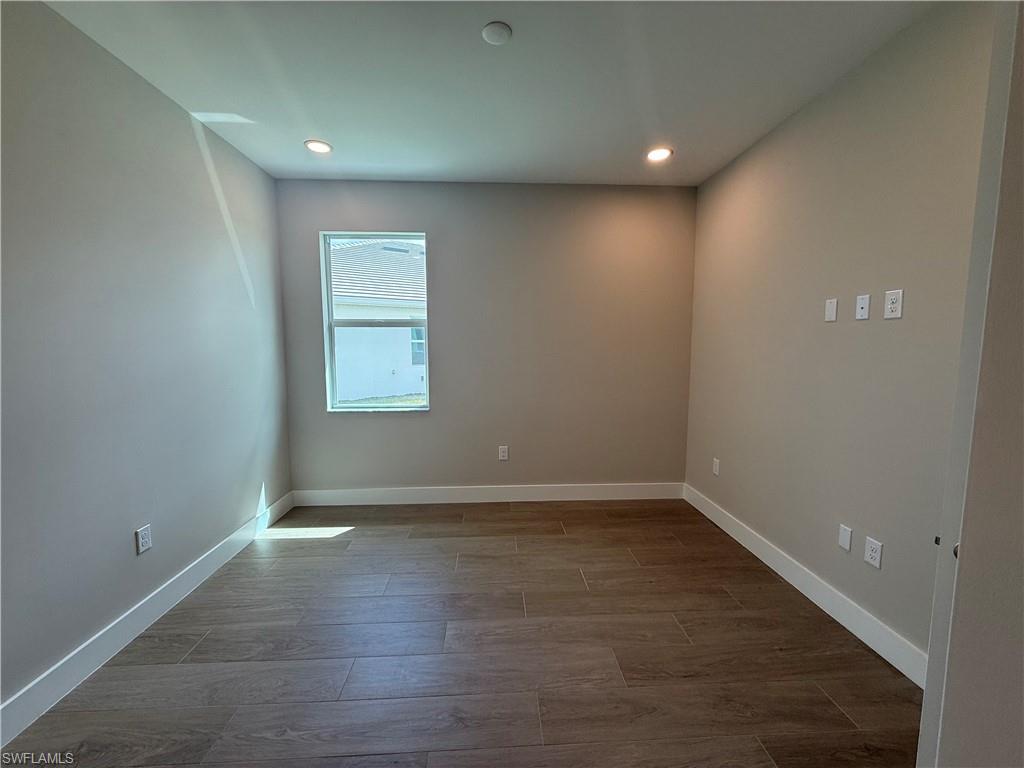 8909 Oceana Way Naples, FL 34114 - Photo 20 of 41 an empty room with wooden floor and windows