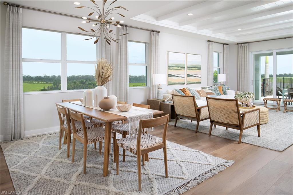 8909 Oceana Way Naples, FL 34114 - Photo 3 of 41 a dining room with furniture a chandelier and wooden floor