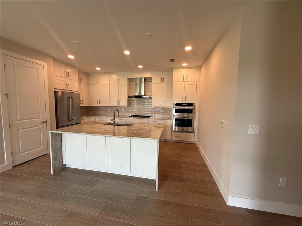 8909 Oceana Way Naples, FL 34114 - Photo 10 of 41 a kitchen with stainless steel appliances granite countertop a refrigerator sink and white cabinets