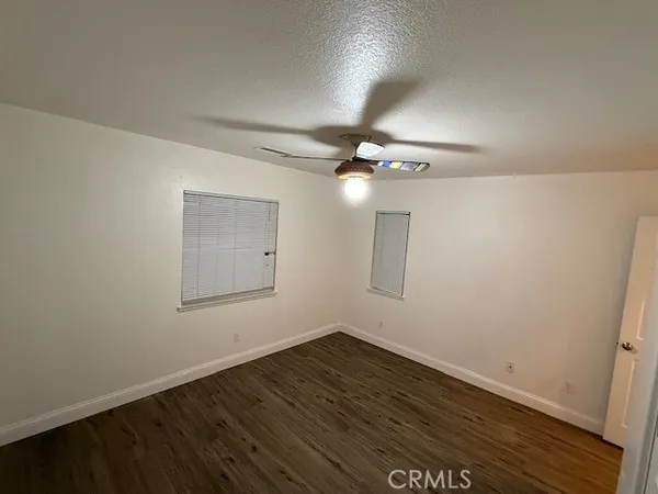 a view of a room with wooden floor and fan