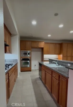 a kitchen with stainless steel appliances granite countertop a stove and a sink