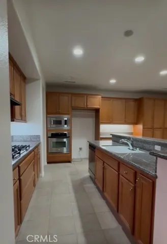 a kitchen with stainless steel appliances granite countertop a stove and a sink