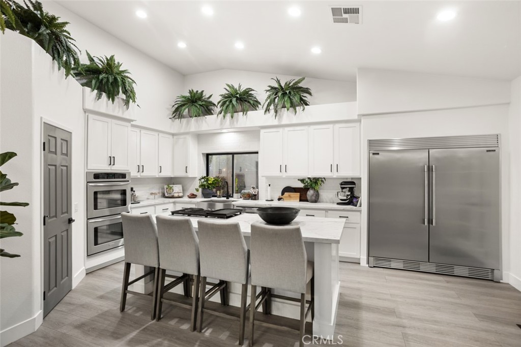 2531 Cottage Drive Corona, CA 92881 - Photo 13 of 48 a kitchen with a table and chairs a refrigerator and a stove