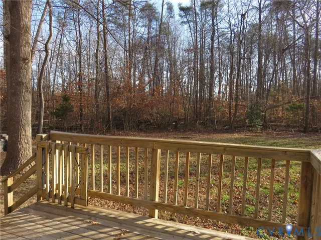 a view of deck with wooden fence and trees
