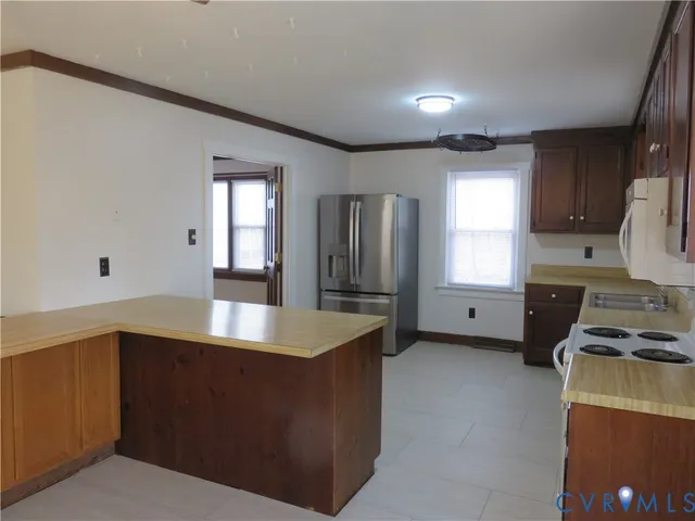 a kitchen with stainless steel appliances granite countertop a sink a stove and a refrigerator