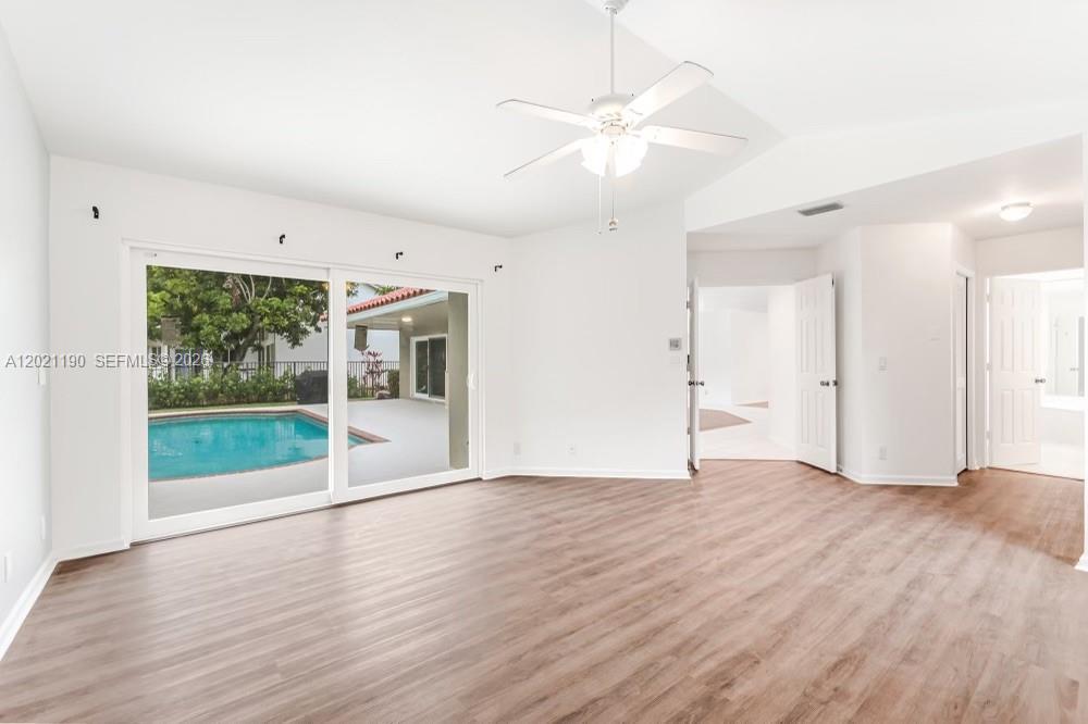 814 Heron Road Weston, FL 33326 - Photo 13 of 27 a view of an empty room with wooden floor and a window