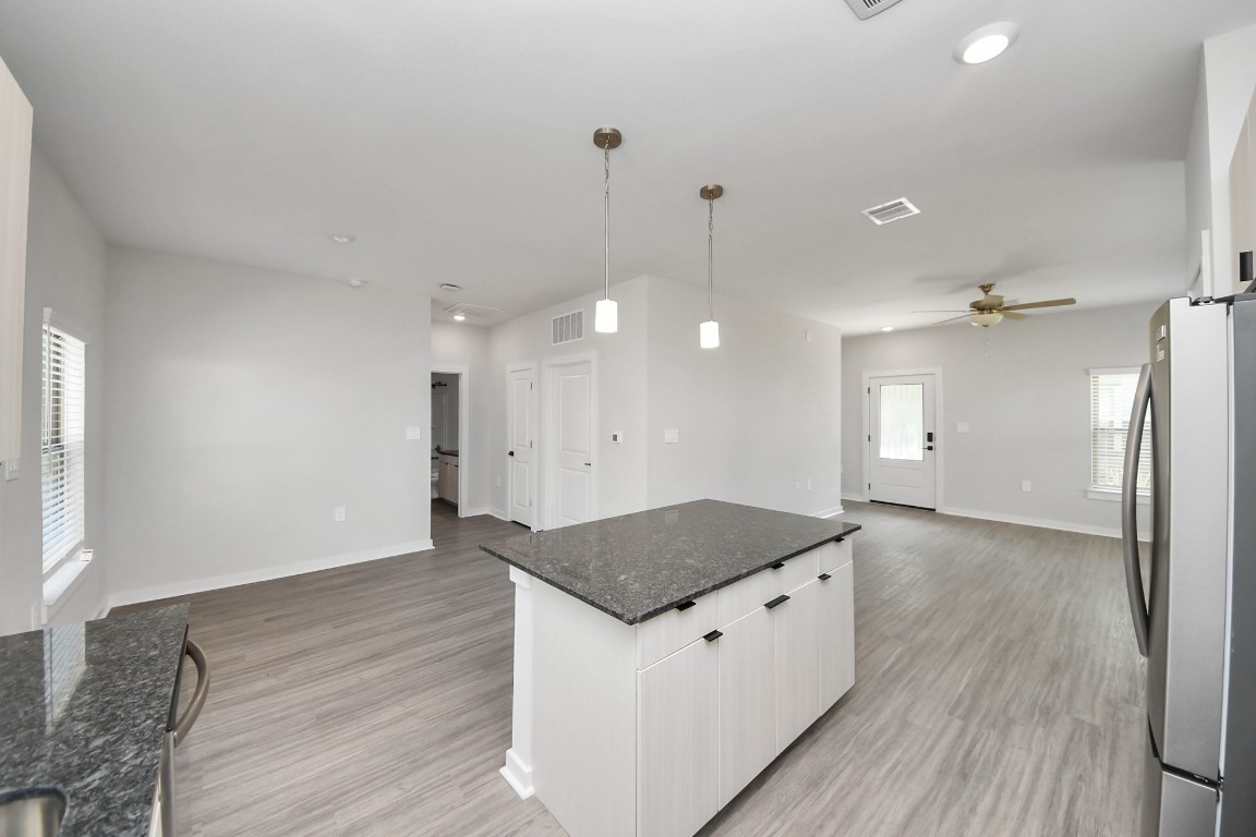 7711 Longmire Road, Unit 5 Conroe, TX 77304 - Photo 39 of 48 Boasting luxury finishes-stylish Island kitchen,granite counters,subway tile backsplash,ample custom cabinet space,stainless appliances,refrigerator,full size washer&dryer included,wood-like flooring throughout,open concept floor plan.