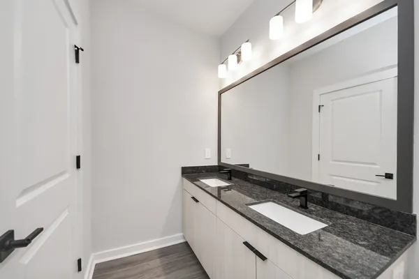 an open kitchen with white cabinets and wooden floor