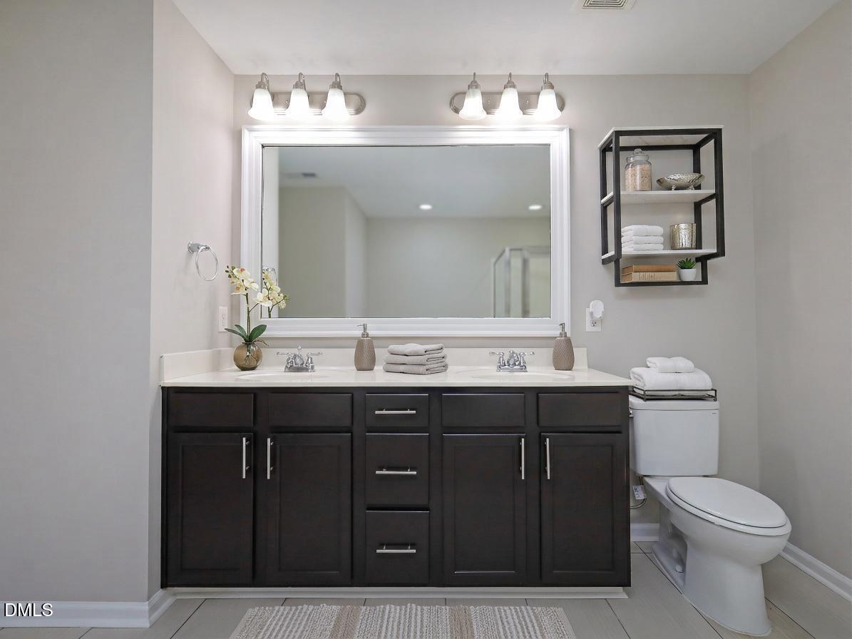 1314 Still Monument Way Raleigh, NC 27603 - Photo 13 of 25 a bathroom with a toilet a sink and mirror