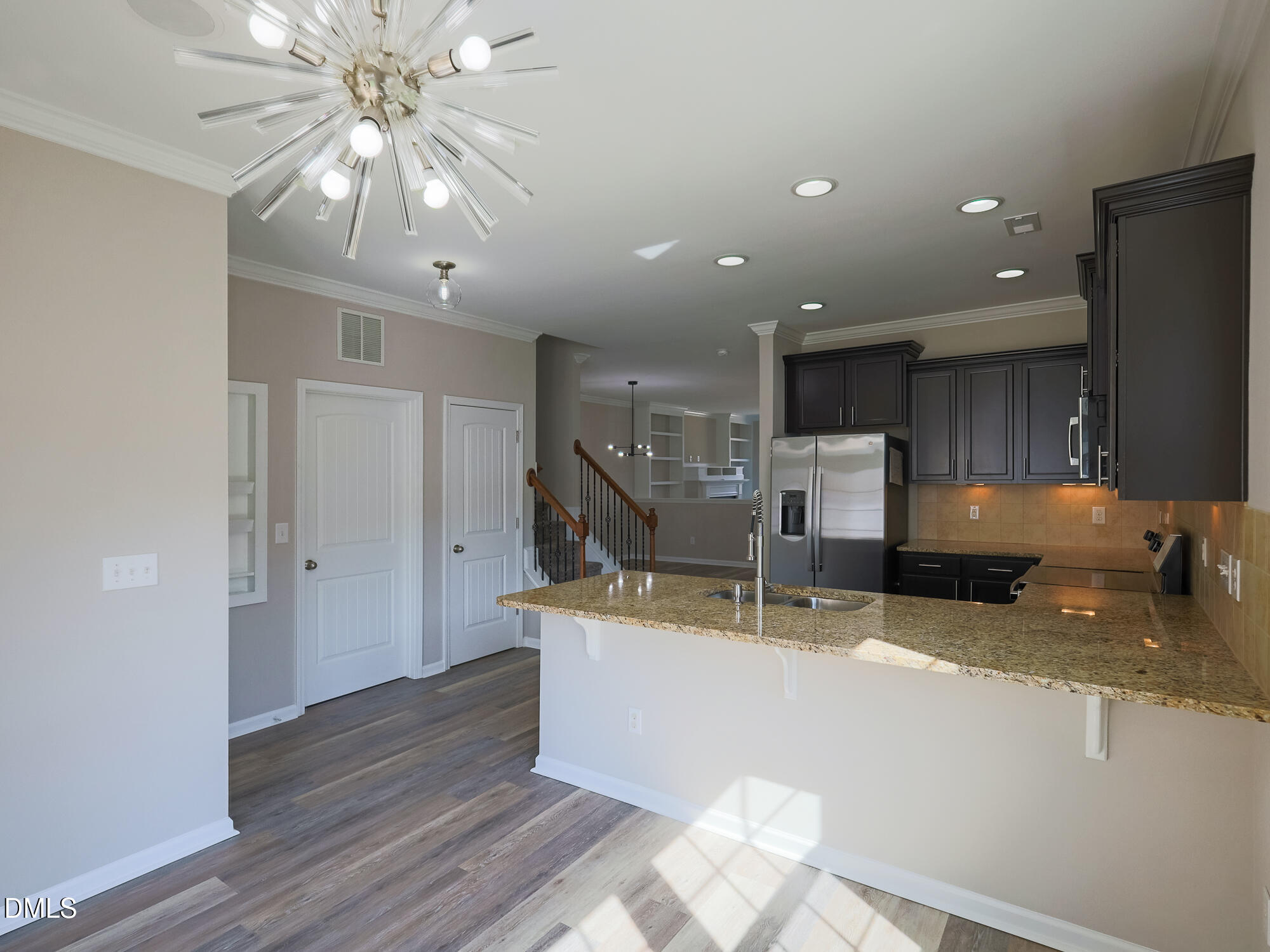 1314 Still Monument Way Raleigh, NC 27603 - Photo 9 of 25 a kitchen with stainless steel appliances granite countertop a sink a stove and a wooden floors
