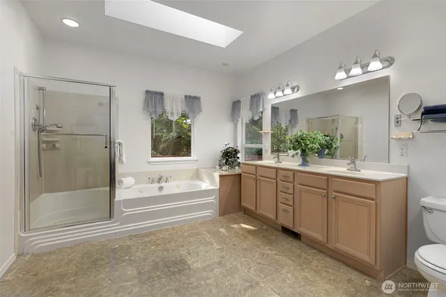 a bathroom with a double vanity sink a toilet a mirror and shower