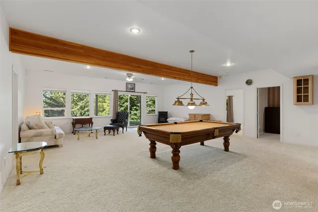 a room with furniture pool table and glass windows