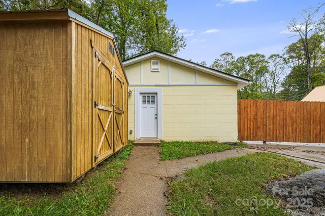 a view of a small house with wooden fence