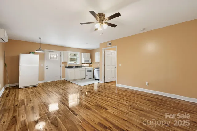 a view of a livingroom with a kitchen counter tops and a ceiling fan