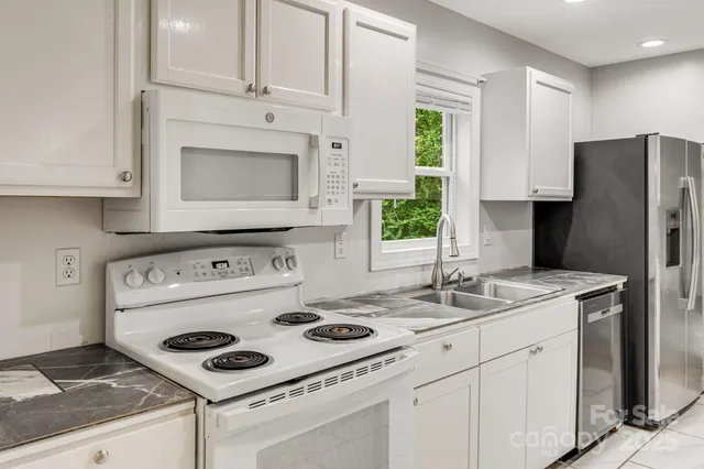 a kitchen with appliances cabinets and a window