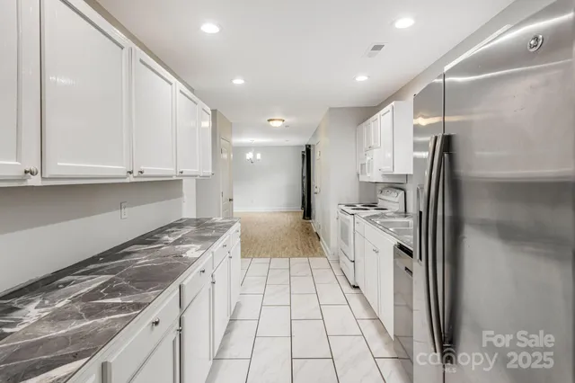 a kitchen with granite countertop a sink stove and refrigerator