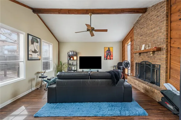 a living room with furniture a flat screen tv and a fireplace