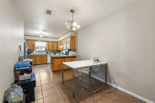 a room with furniture a chandelier and kitchen view