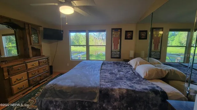 a bedroom with a large bed and a flat tv screen on dresser
