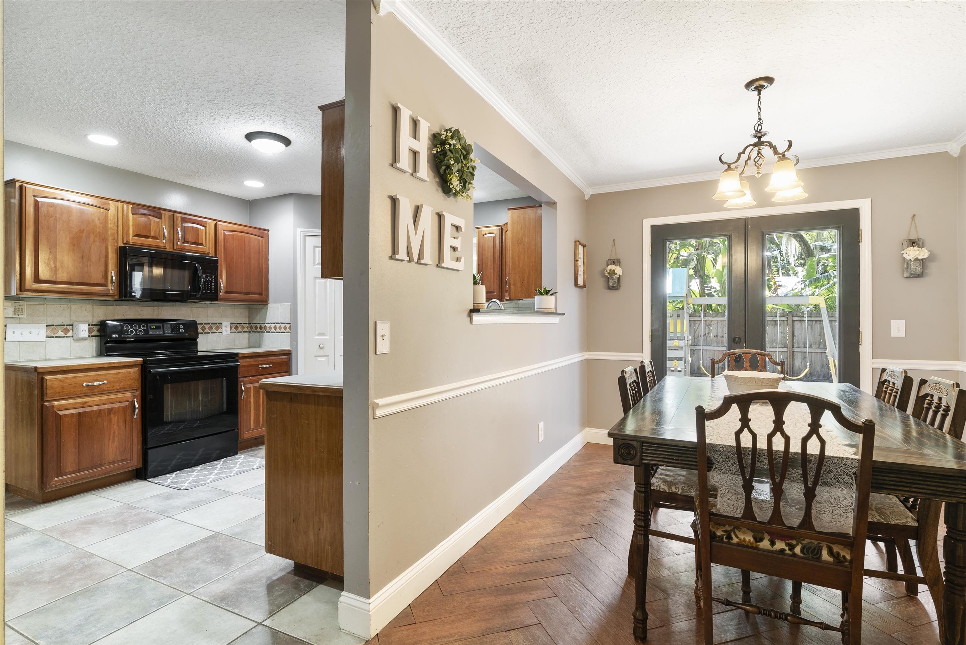 246 Mimosa Road St. Augustine, FL 32086 - Photo 19 of 45 a kitchen with stainless steel appliances granite countertop a stove a refrigerator a kitchen island a dining table and chairs with wooden floor