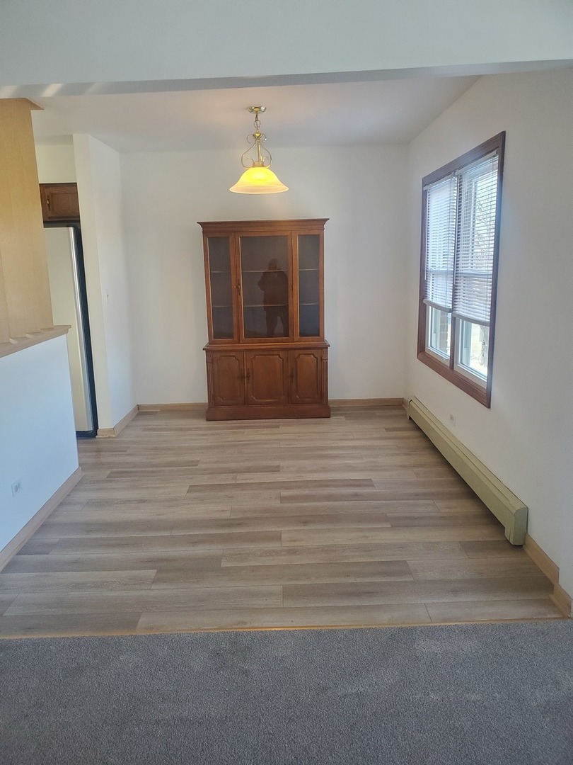 508 Ida Court, Unit 2 Mount Prospect, IL 60056 - Photo 6 of 13 a view of an empty room with wooden floor and a window