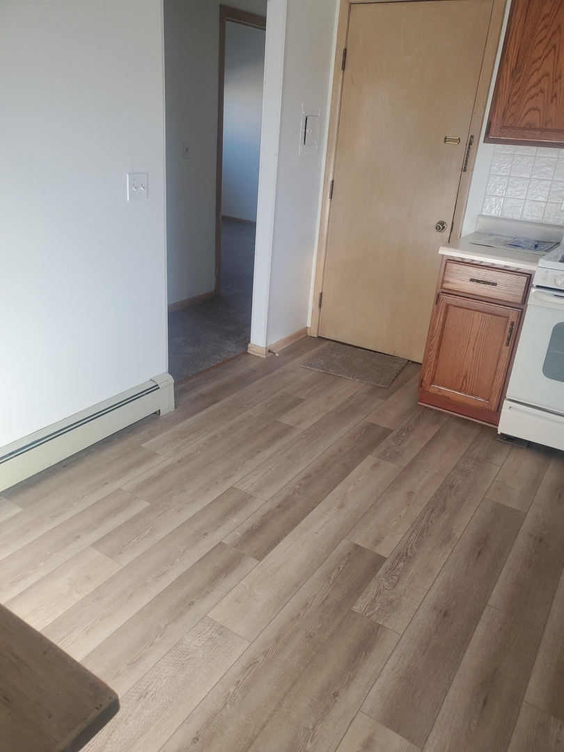 508 Ida Court, Unit 2 Mount Prospect, IL 60056 - Photo 8 of 13 an empty room with wooden floor and cabinet