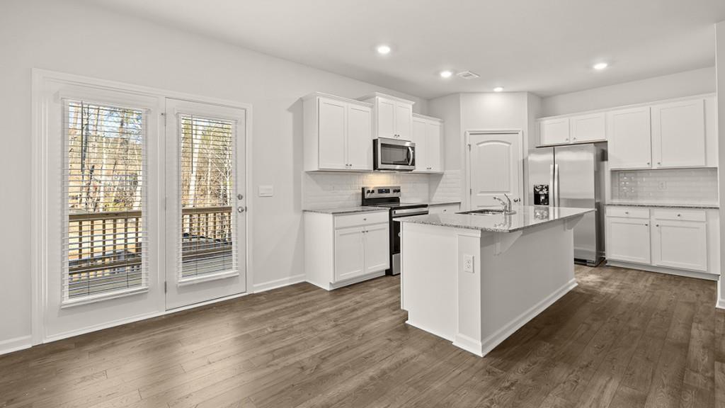 47 Rustin Ridge Dahlonega, GA 30533 - Photo 4 of 27 a kitchen with kitchen island a sink a stove a refrigerator and white cabinets