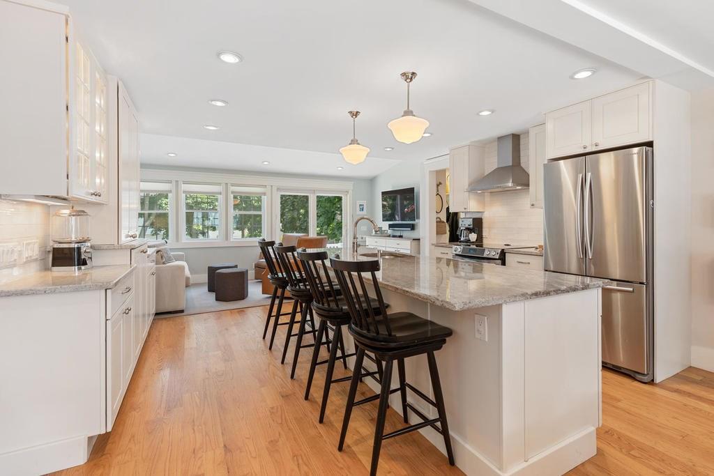 18 Moccasin Path Arlington, MA 02474 - Photo 10 of 33 a kitchen with stainless steel appliances a dining table chairs refrigerator and microwave