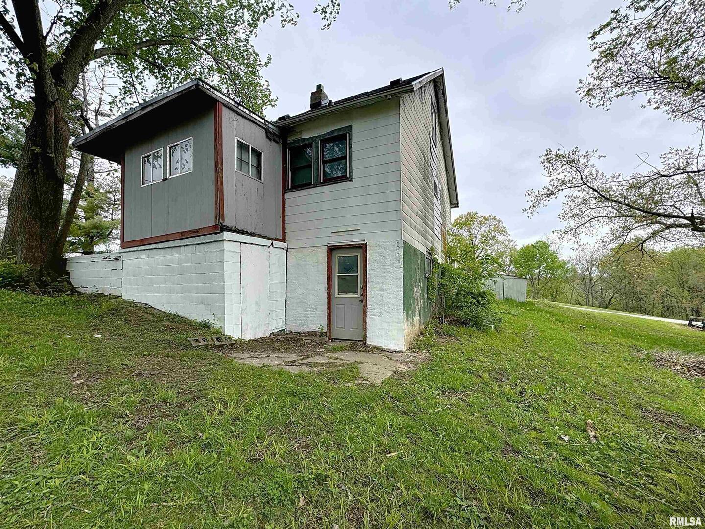 204 Main Avenue Matherville, IL 61263 - Photo 26 of 27 a white house that has a small yard and trees in the background