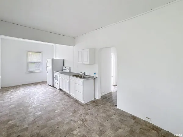 a view of a kitchen with refrigerator and windows