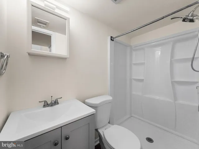 an empty room with wooden floor and mirror