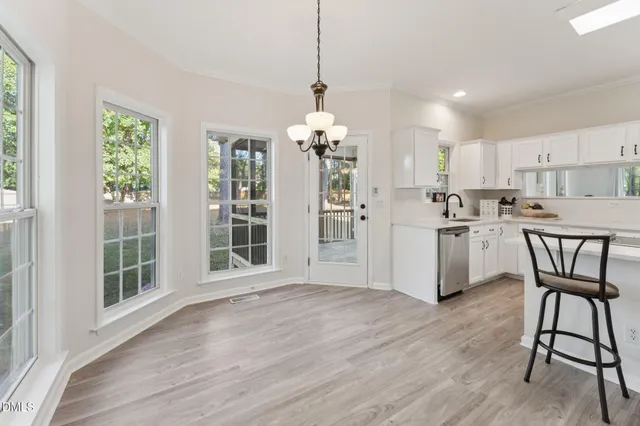 a kitchen with granite countertop a sink stove a table and chairs