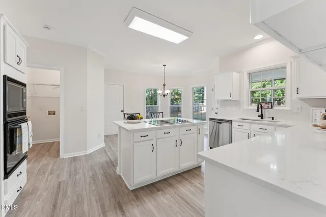 a dining room with furniture wooden floor a potted plant and a chandelier