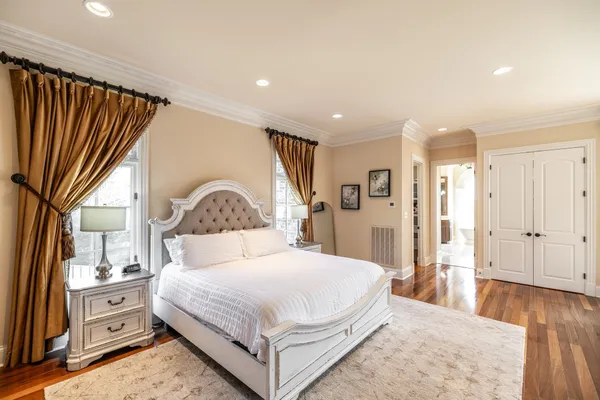 a spacious bedroom with a bed and a flat screen tv