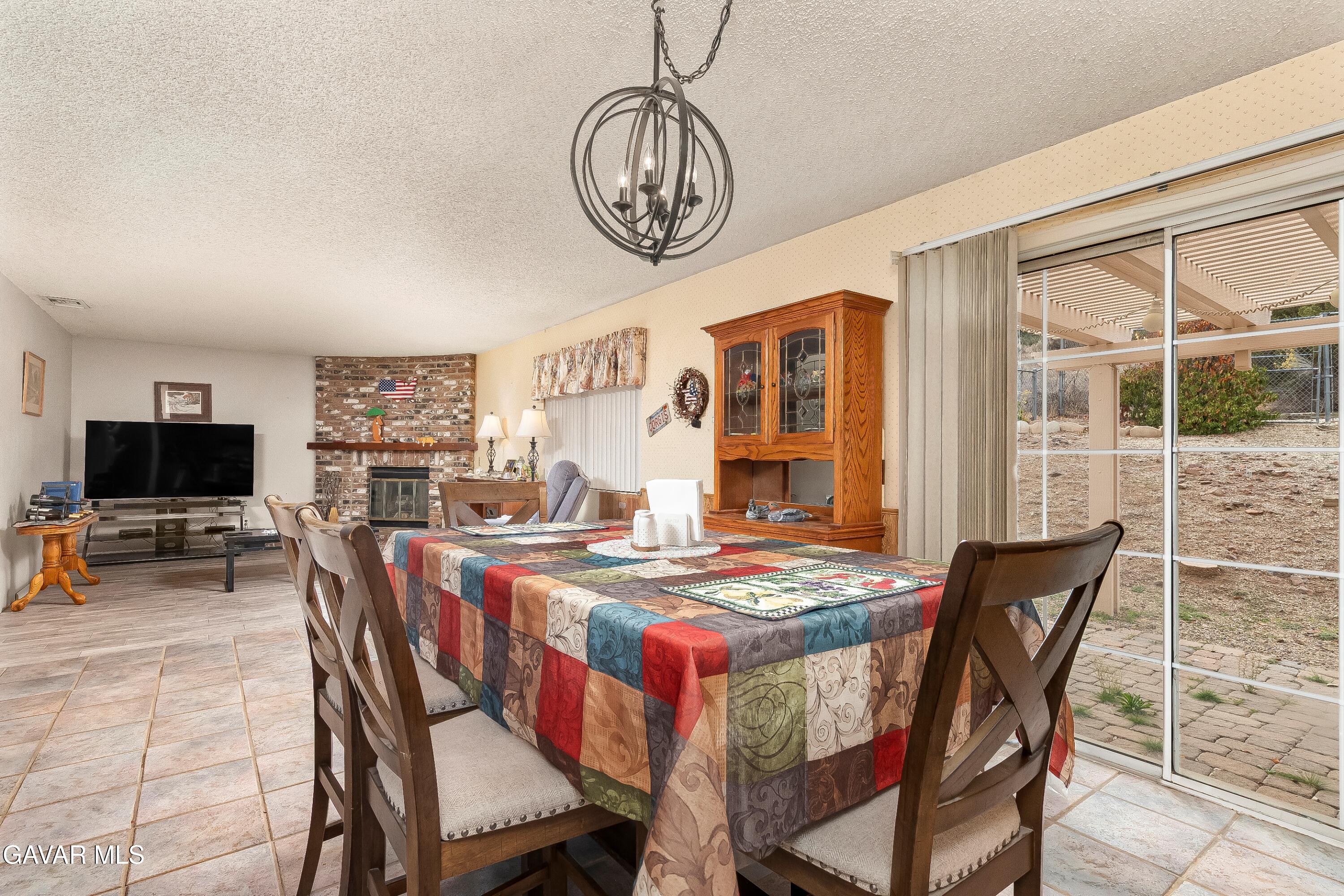31741 Lake Meadow Road Acton, CA 93510 - Photo 11 of 59 a dining room with furniture a flat screen tv and a large window