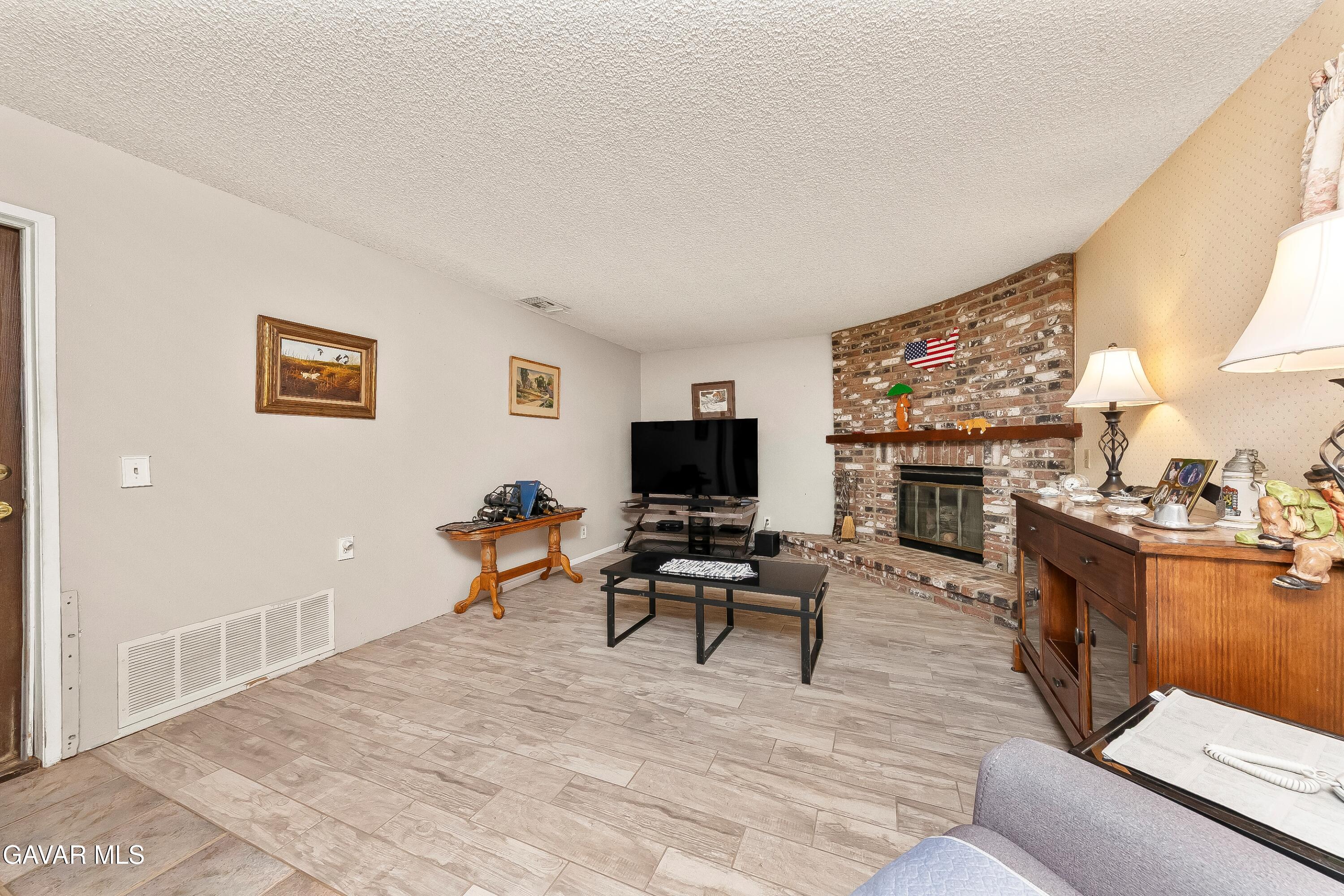 31741 Lake Meadow Road Acton, CA 93510 - Photo 9 of 59 a living room with furniture a flat screen tv and a fireplace