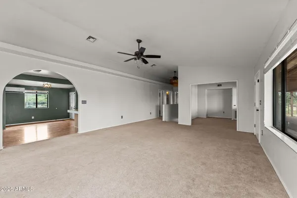 an empty room with windows and ceiling fan