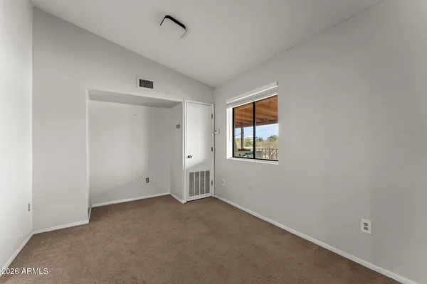 a view of a hallway with a ceiling fan and windows
