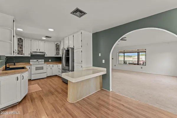 a kitchen with cabinets and wooden floor