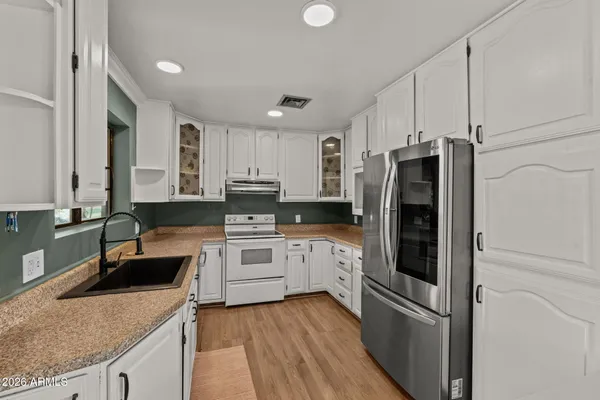 a large kitchen with stainless steel appliances kitchen island granite countertop a stove a sink and a refrigerator