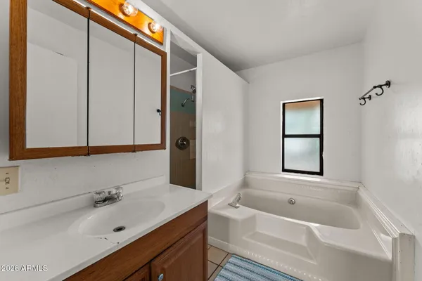 an empty room with windows and ceiling fan