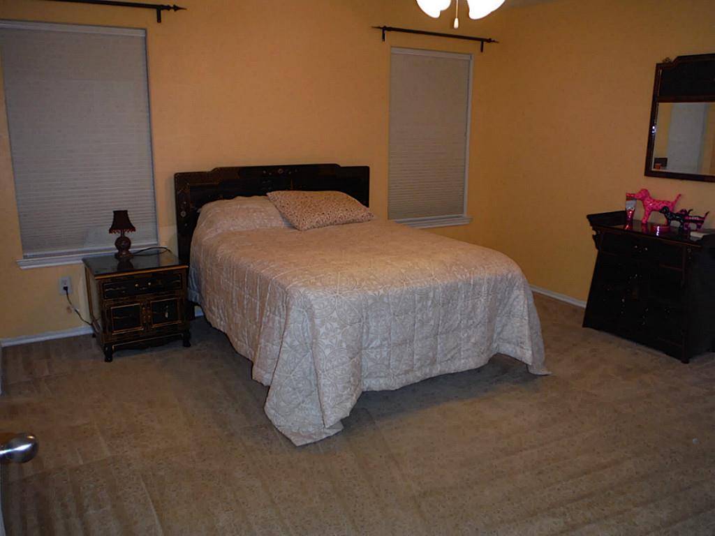 3142 Aspen Fair Trail Spring, TX 77389 - Photo 13 of 22 Cozy bedroom with warm walls, featuring two windows with blinds, and is carpeted.