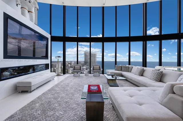 a living room with furniture and a floor to ceiling window
