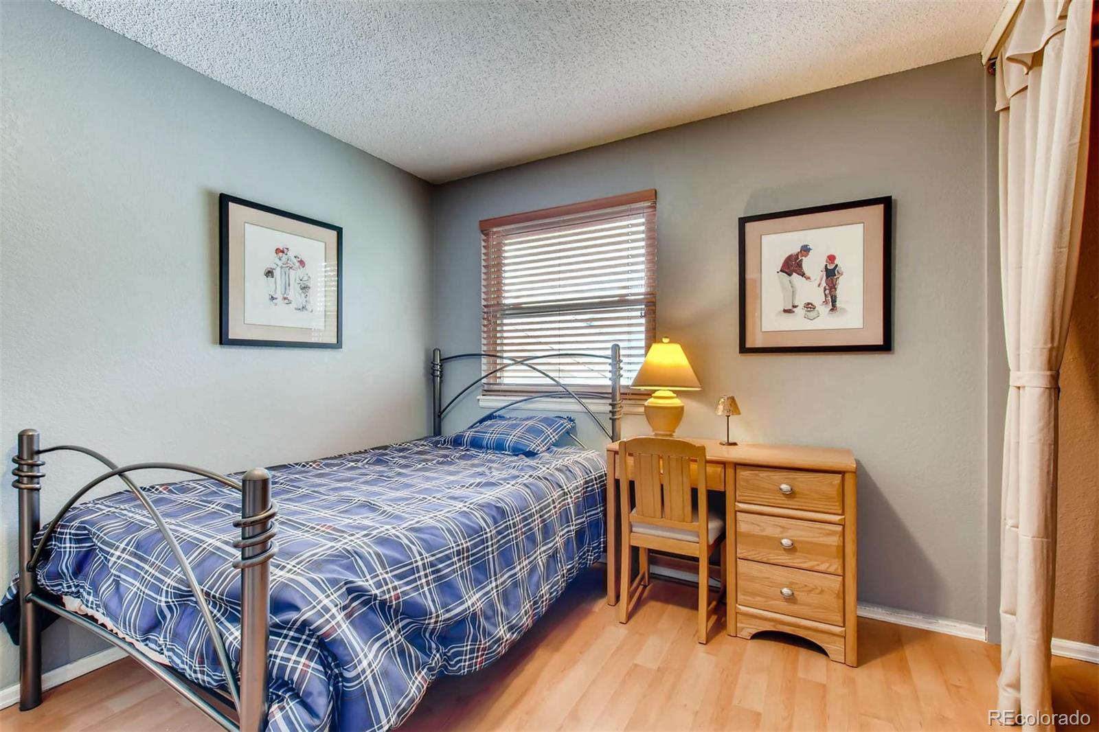 13360 Cherry Circle Thornton, CO 80241 - Photo 19 of 26 a bedroom with a bed and wooden floor