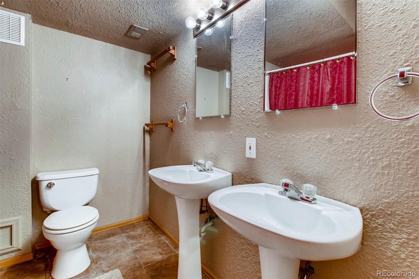 13360 Cherry Circle Thornton, CO 80241 - Photo 23 of 26 a bathroom with a toilet sink and mirror