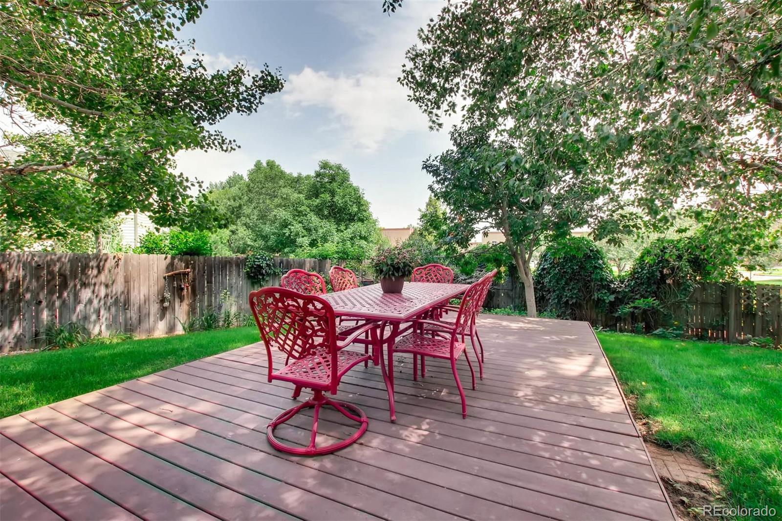 13360 Cherry Circle Thornton, CO 80241 - Photo 24 of 26 a view of a deck with table and chairs and wooden floor
